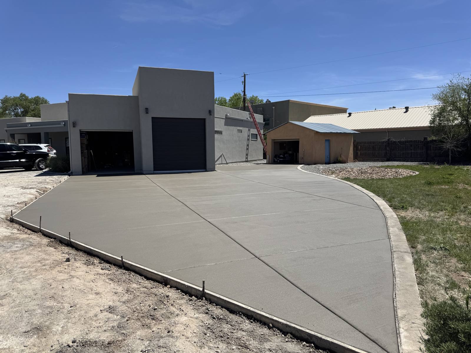 Newly poured concrete driveway curving up to a garage